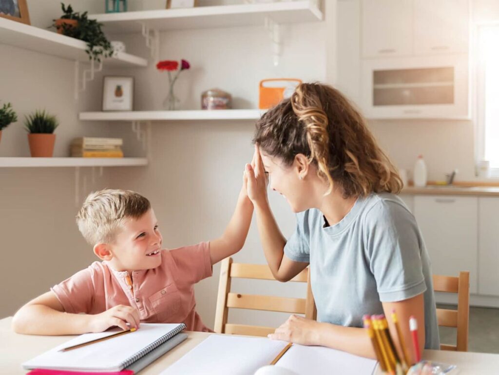 Teacher giving a high five to a child while studying at therapy centre