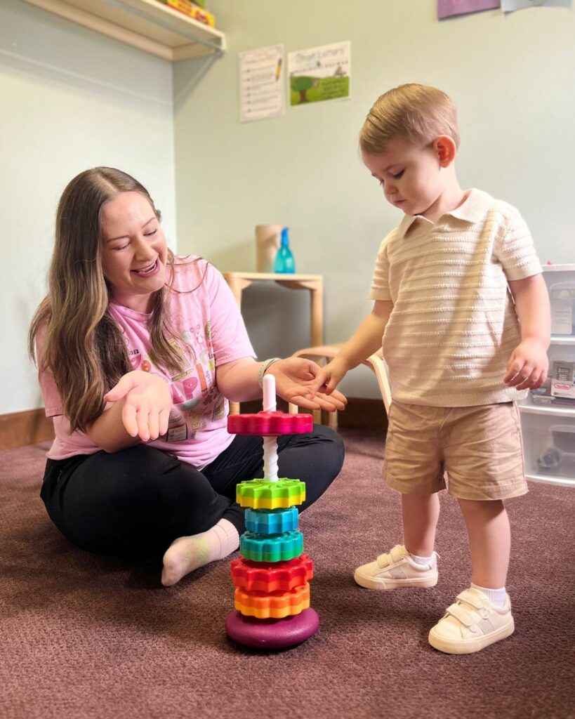 Therapist playing stacking game with toddler